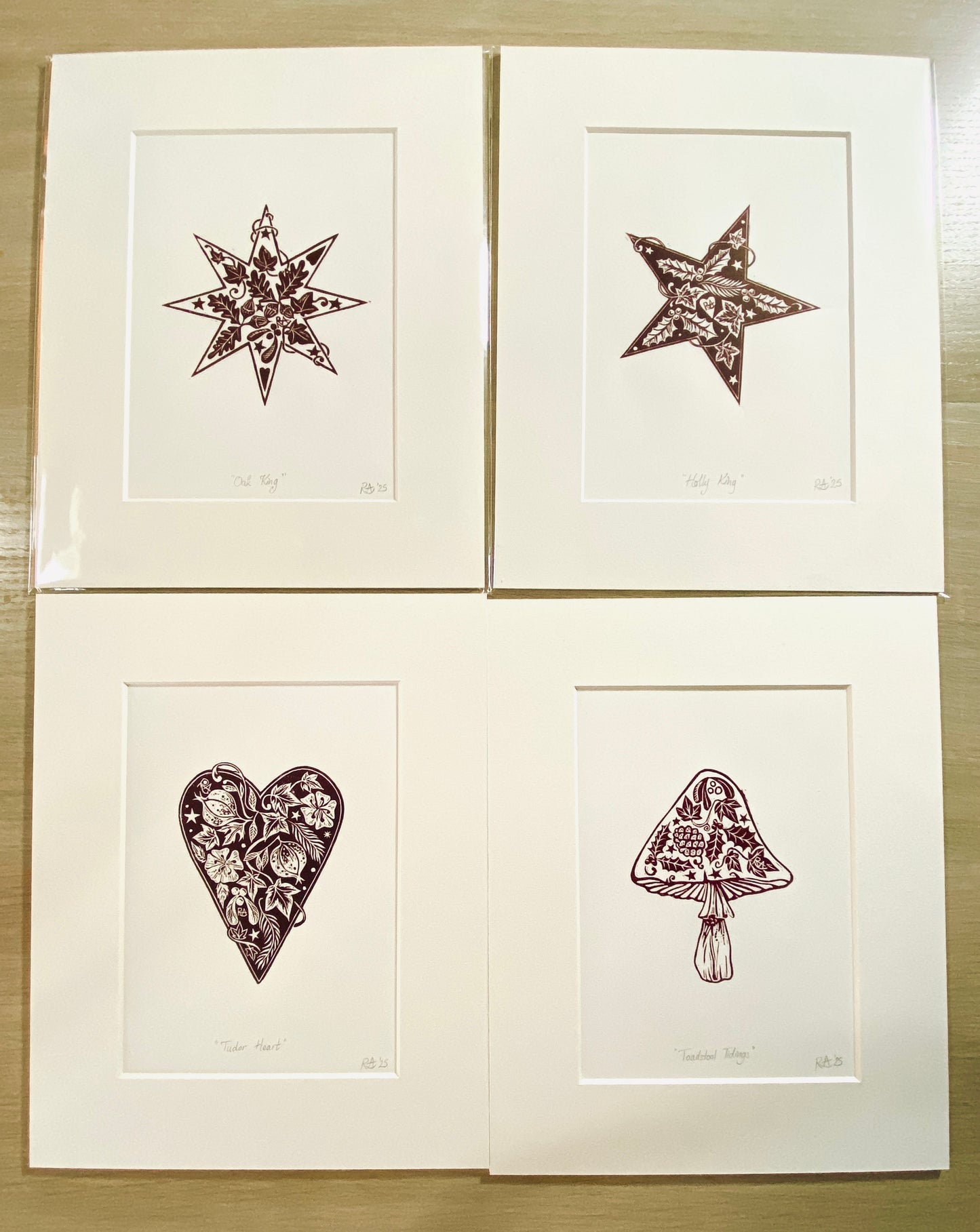 Four framed illustrations of a star, heart, mushroom, and other shapes on a wooden surface.