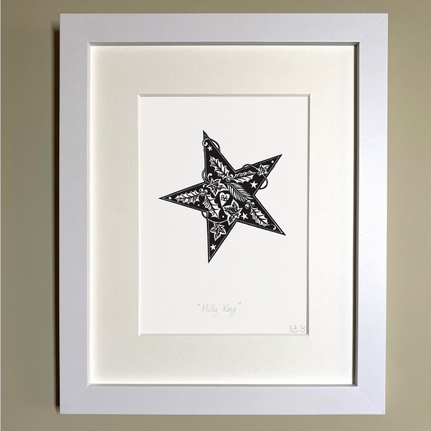 Framed black and white star artwork on a beige wall