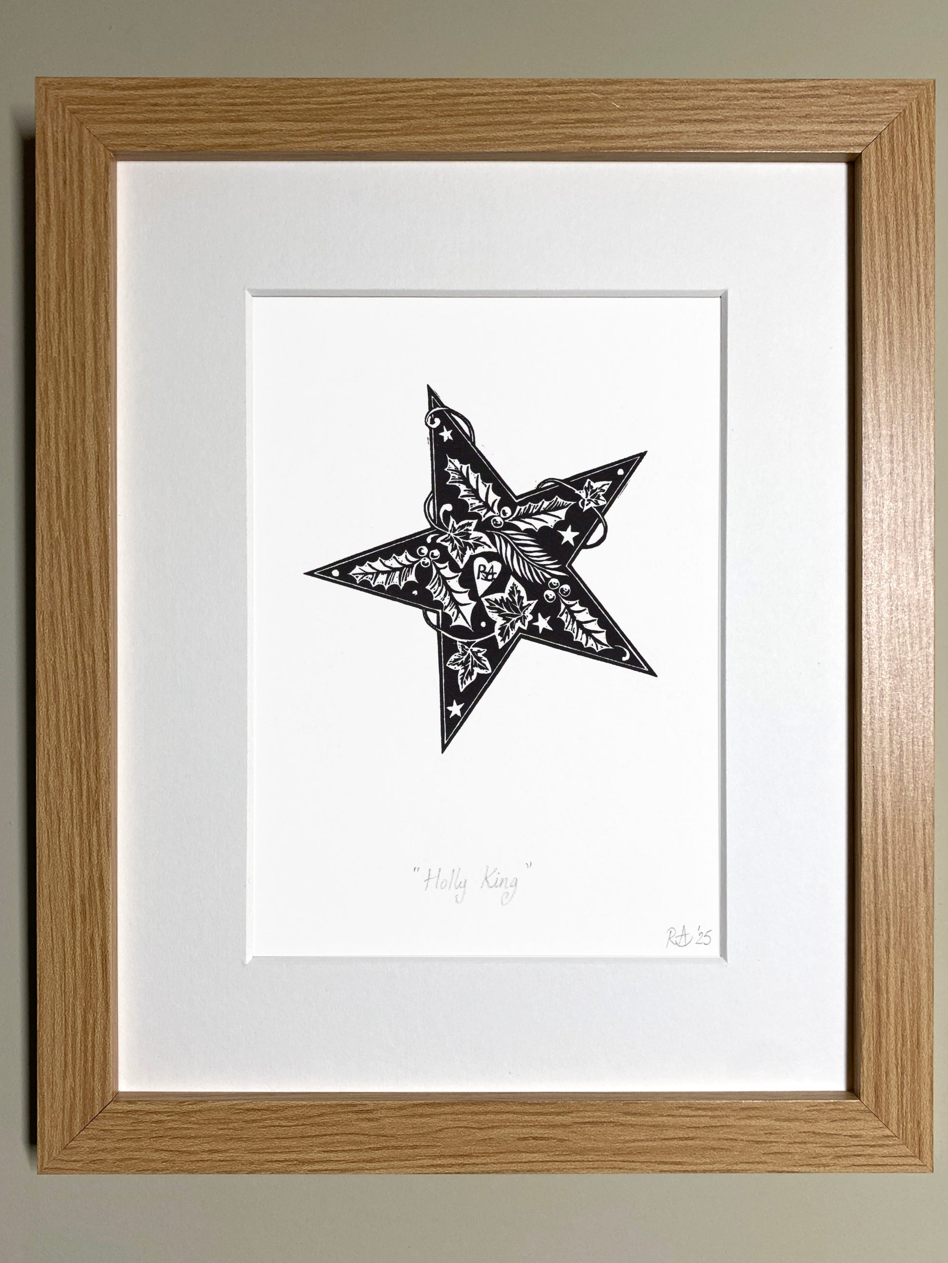 Framed artwork of a black star with white patterns on a white background