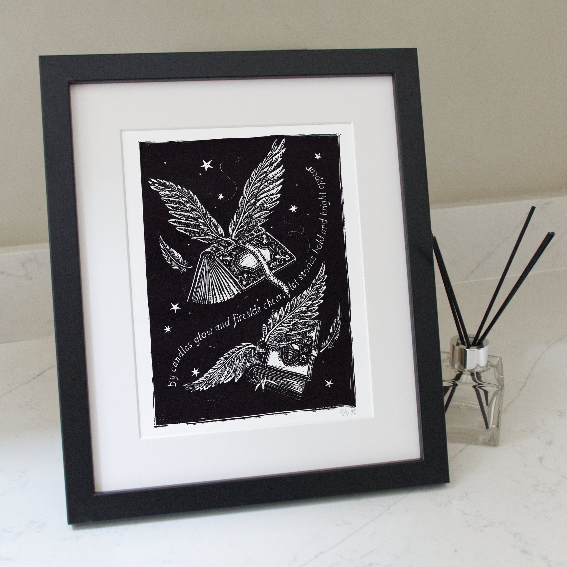 Framed black and white artwork with a winged creature and text on a white surface.