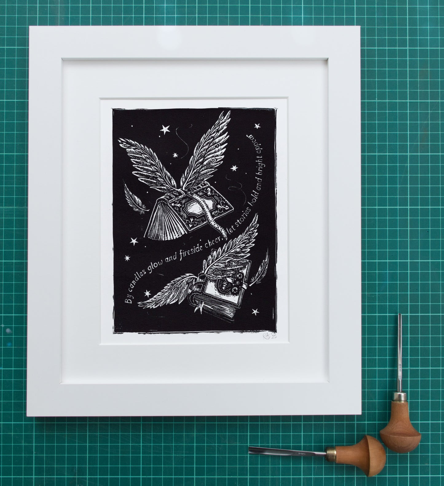 Framed black and white artwork of a winged heart and other symbols on a green grid background.