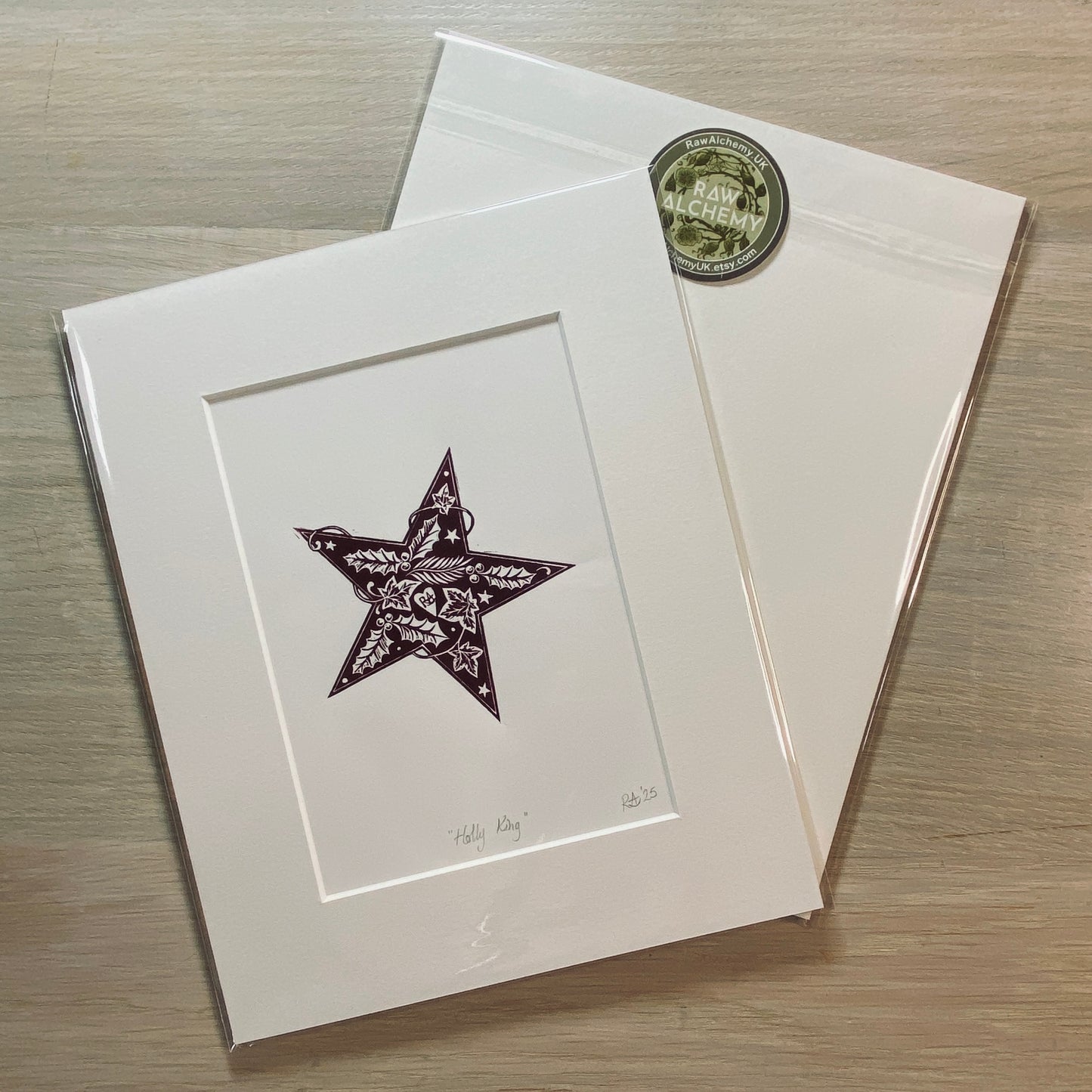 Matted artwork of a star with a green stamp on a wooden surface