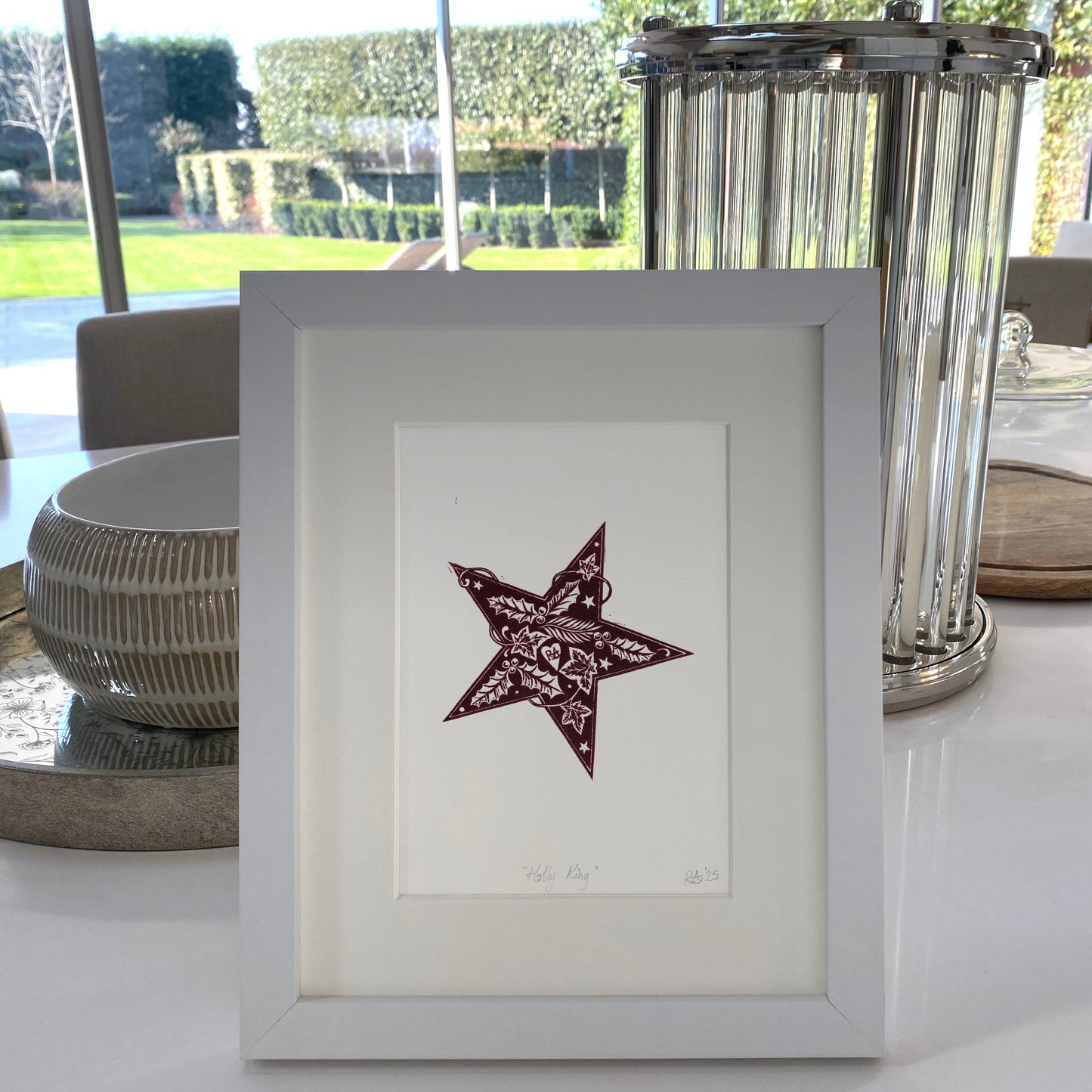 Framed artwork of a star on a table with decorative elements