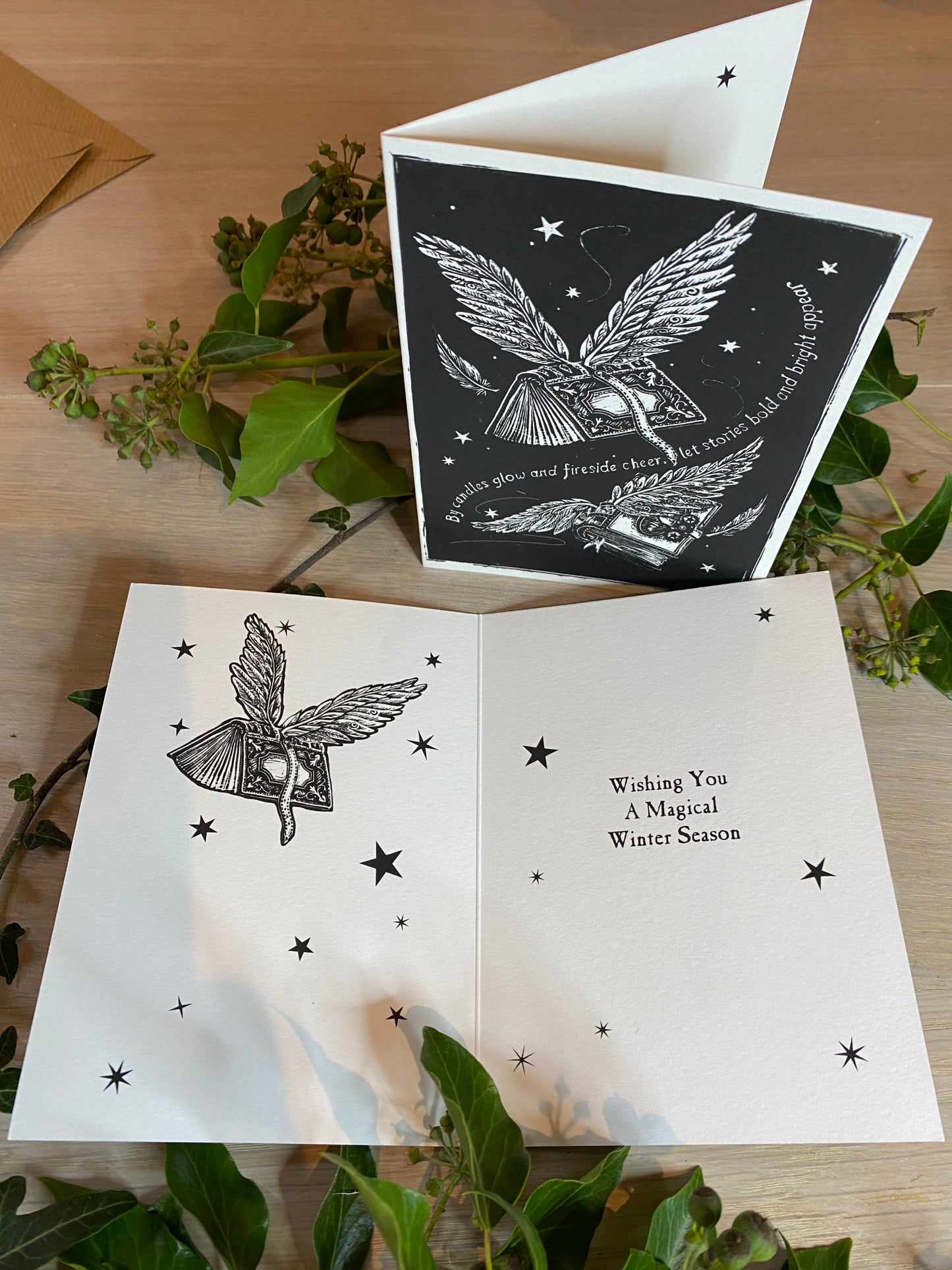 Greeting card with magic design and text on a wooden surface with leaves.