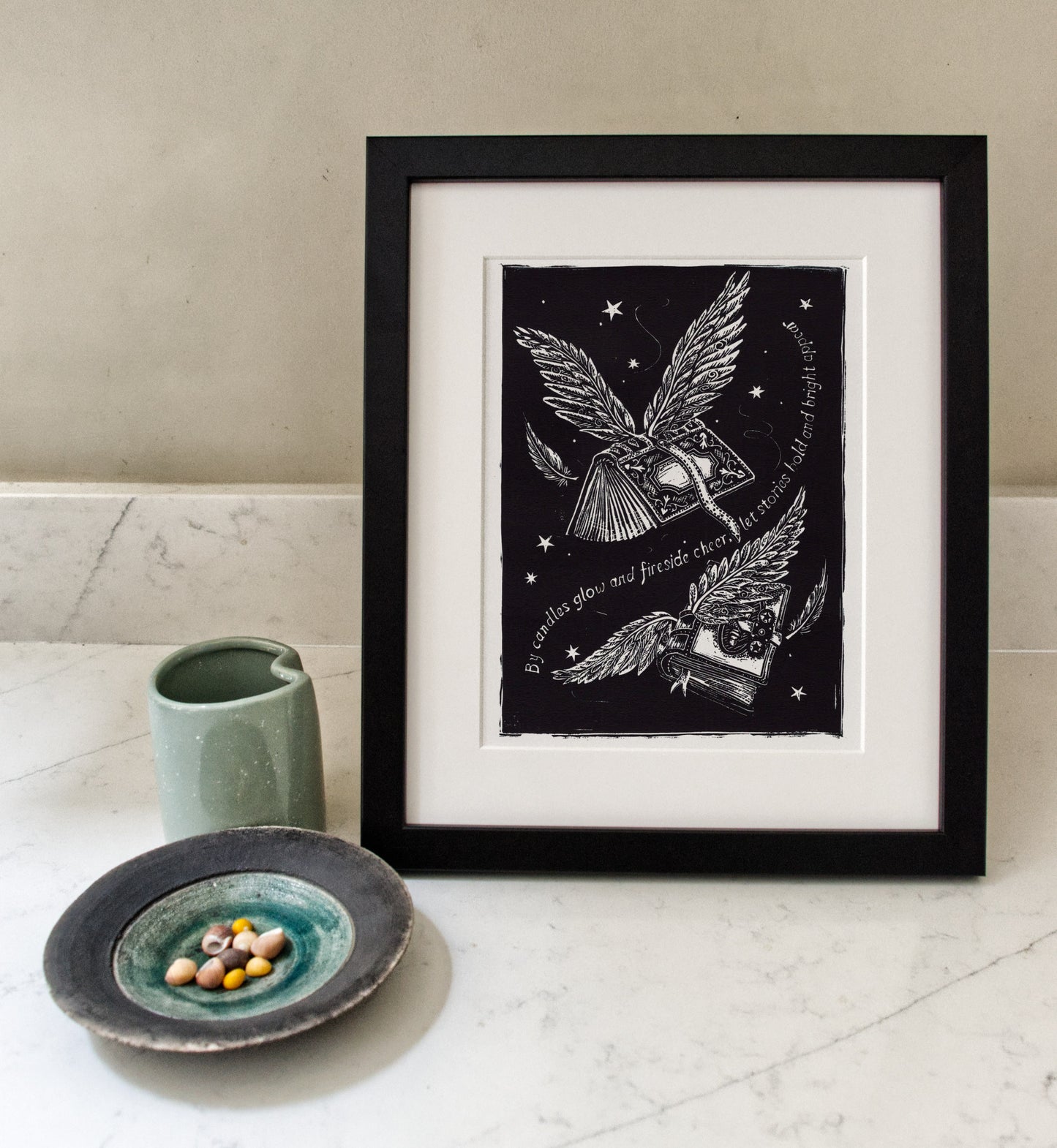 Framed black and white artwork of books flying on a white surface with a neutral background