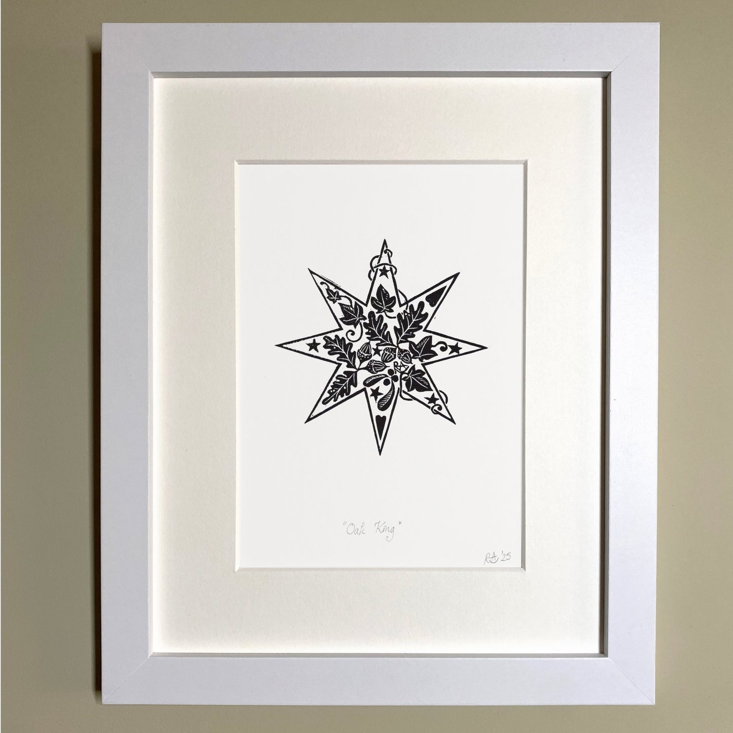 Framed black and white star illustration on a beige wall