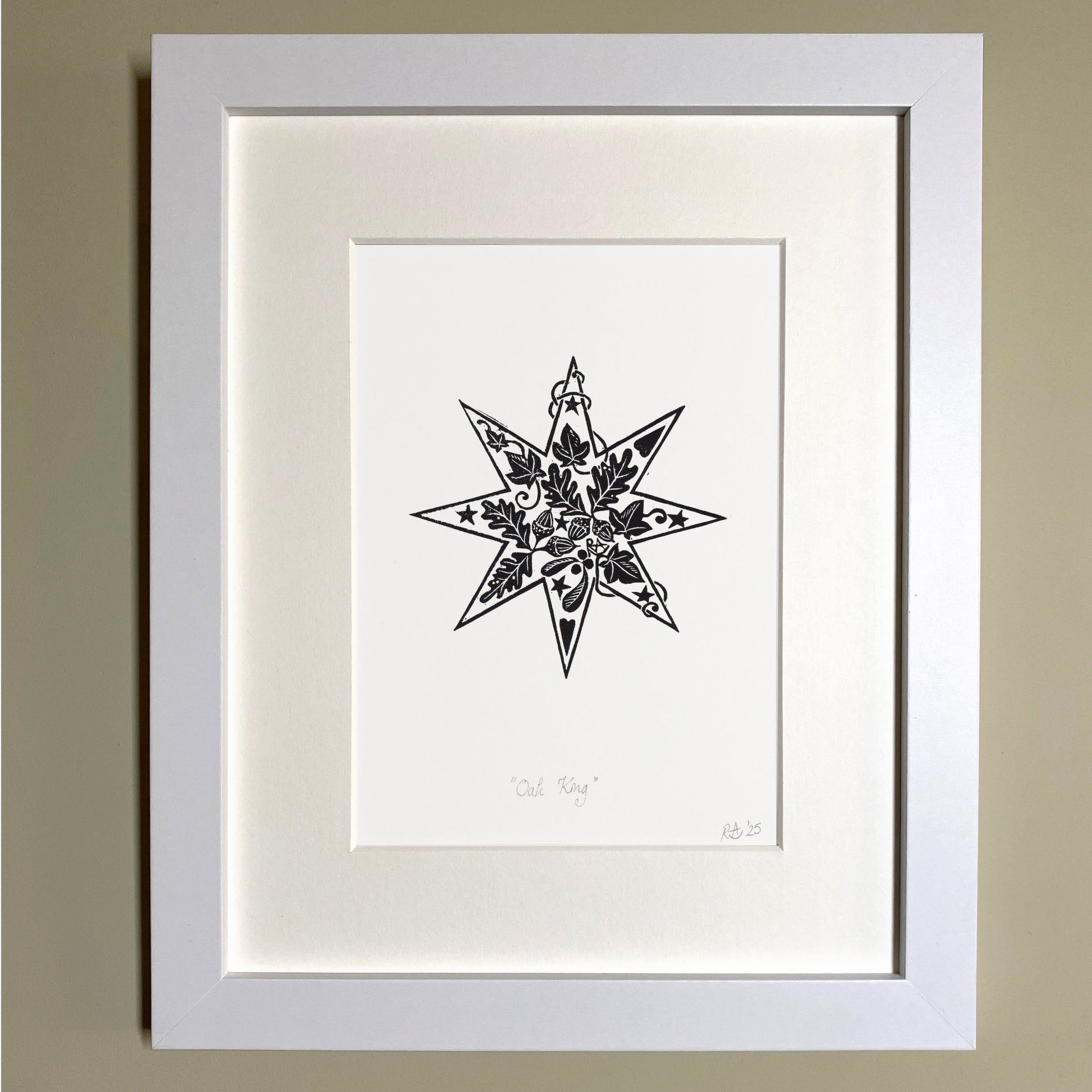 Framed black and white star illustration on a beige wall