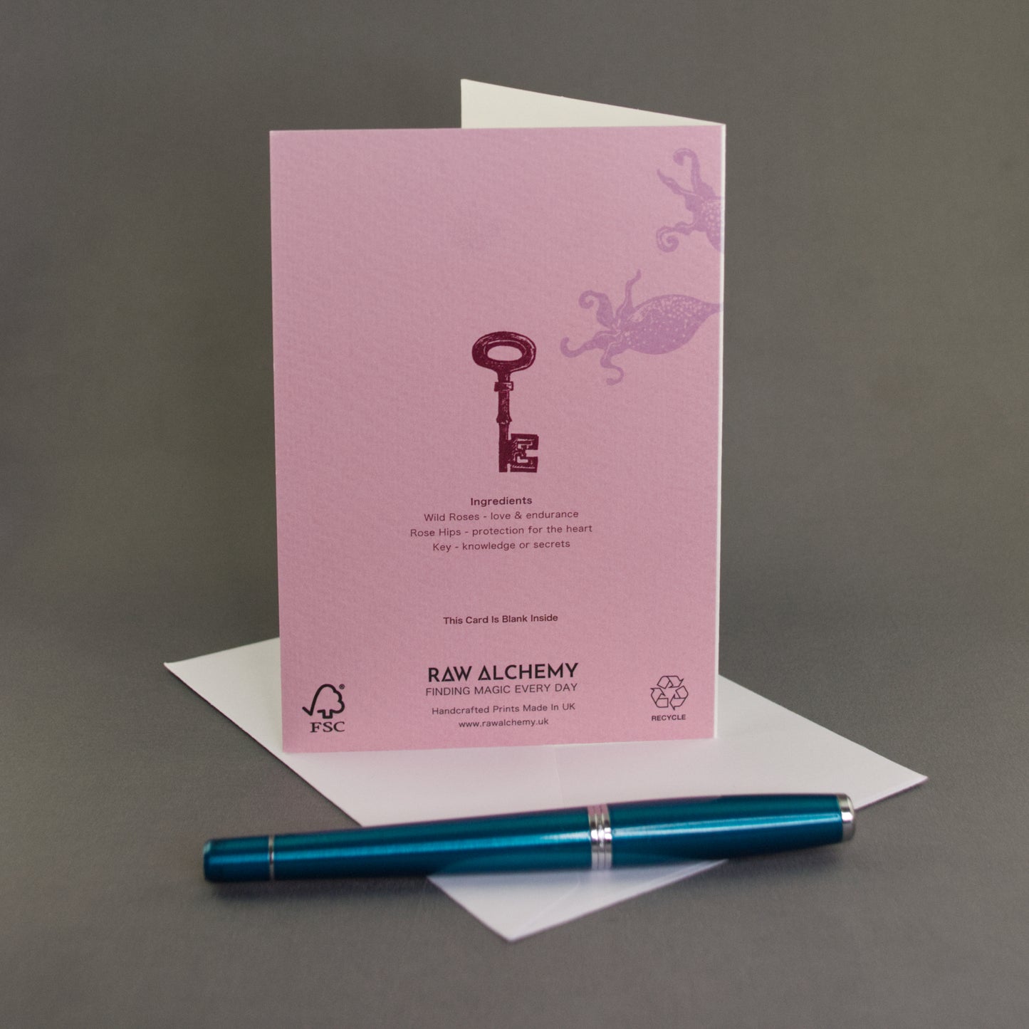 Pink card with key design and 'Raw Alchemy' branding on a gray background