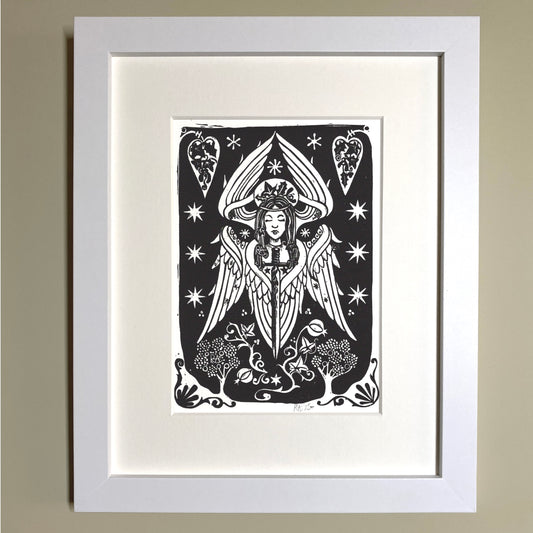 Framed black and white artwork of a stylized angel with stars and hearts on a beige wall.