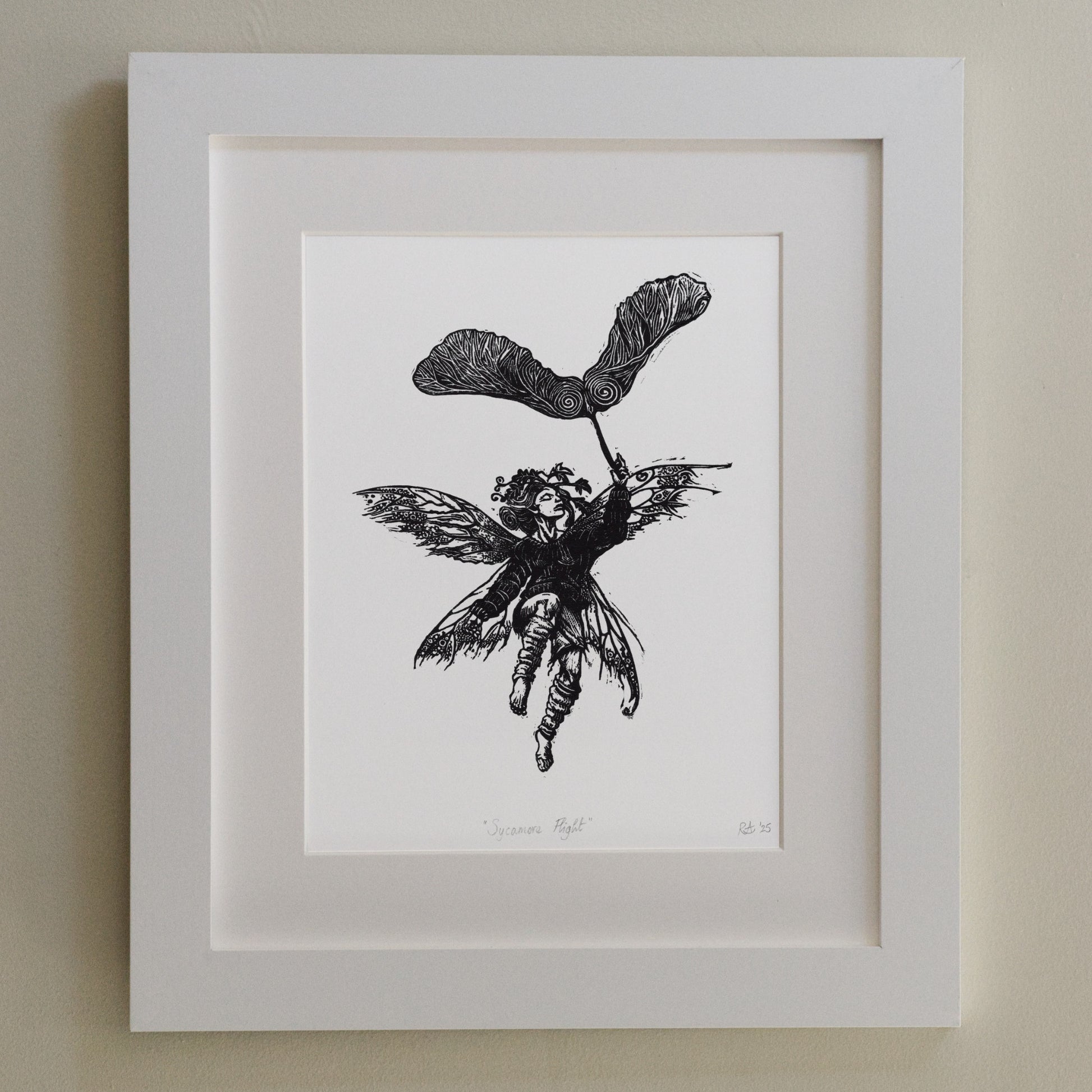 Framed black and white illustration of a fairy on a beige wall