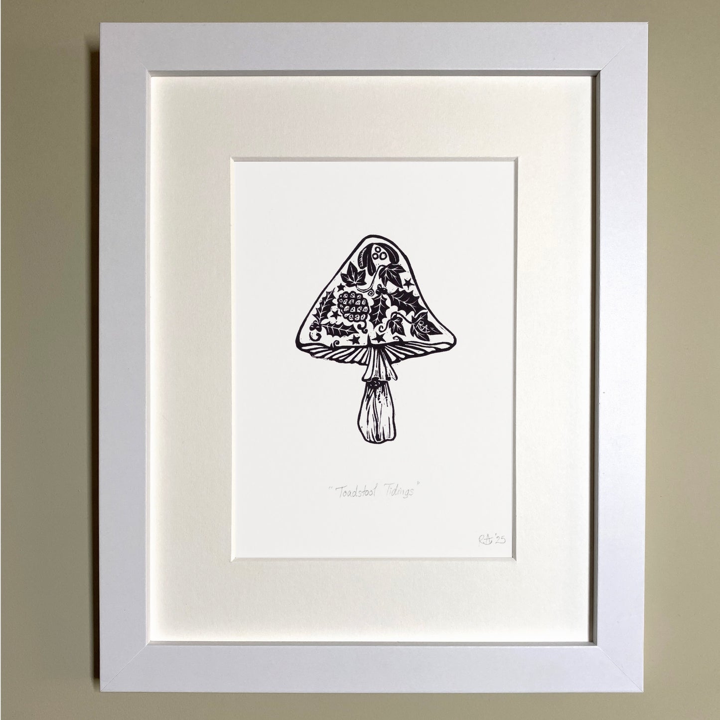 Framed black and white illustration of a mushroom on a beige wall