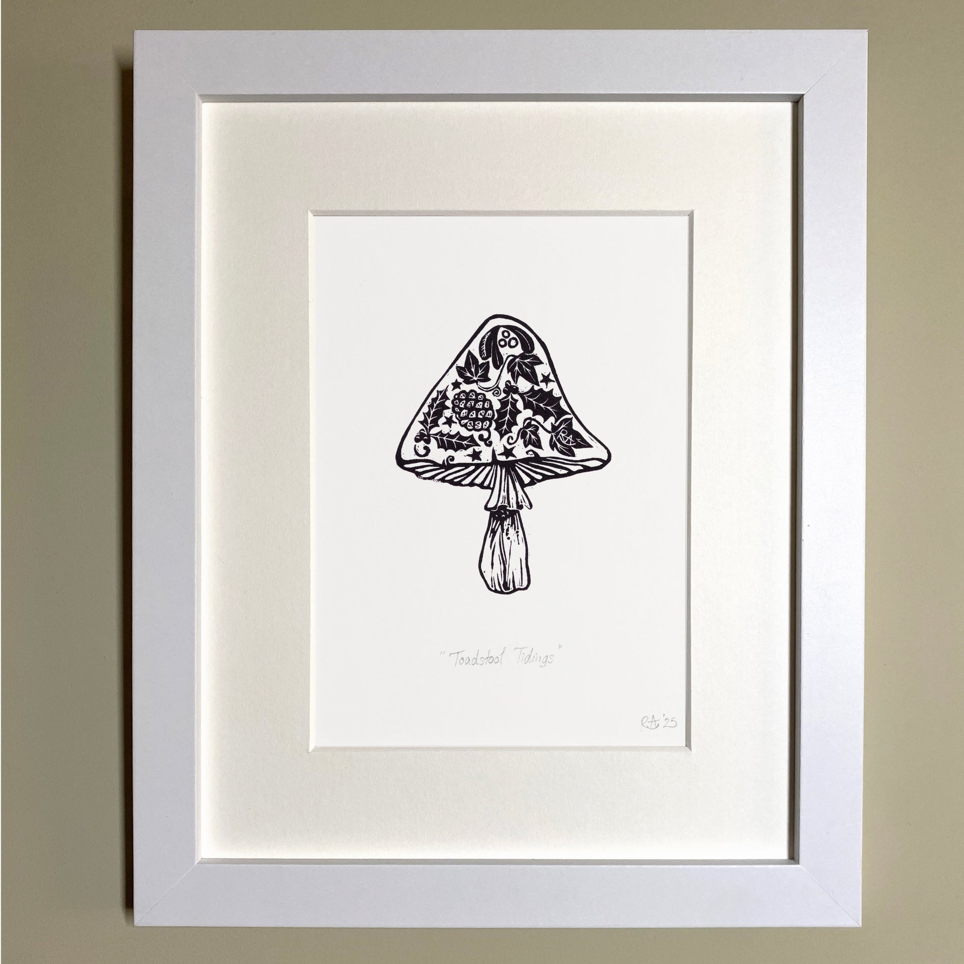 Framed black and white illustration of a mushroom on a beige wall