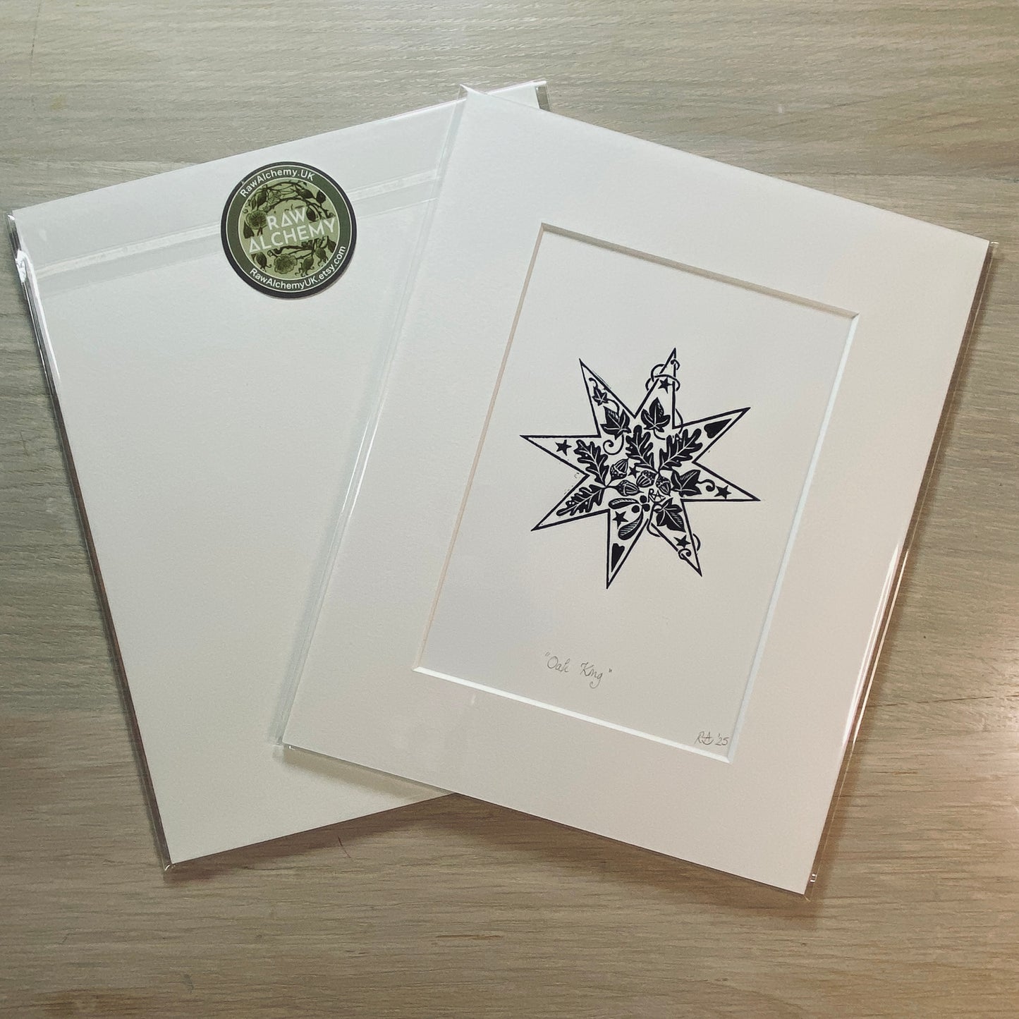 White card with black star design and green circular logo on a wooden surface