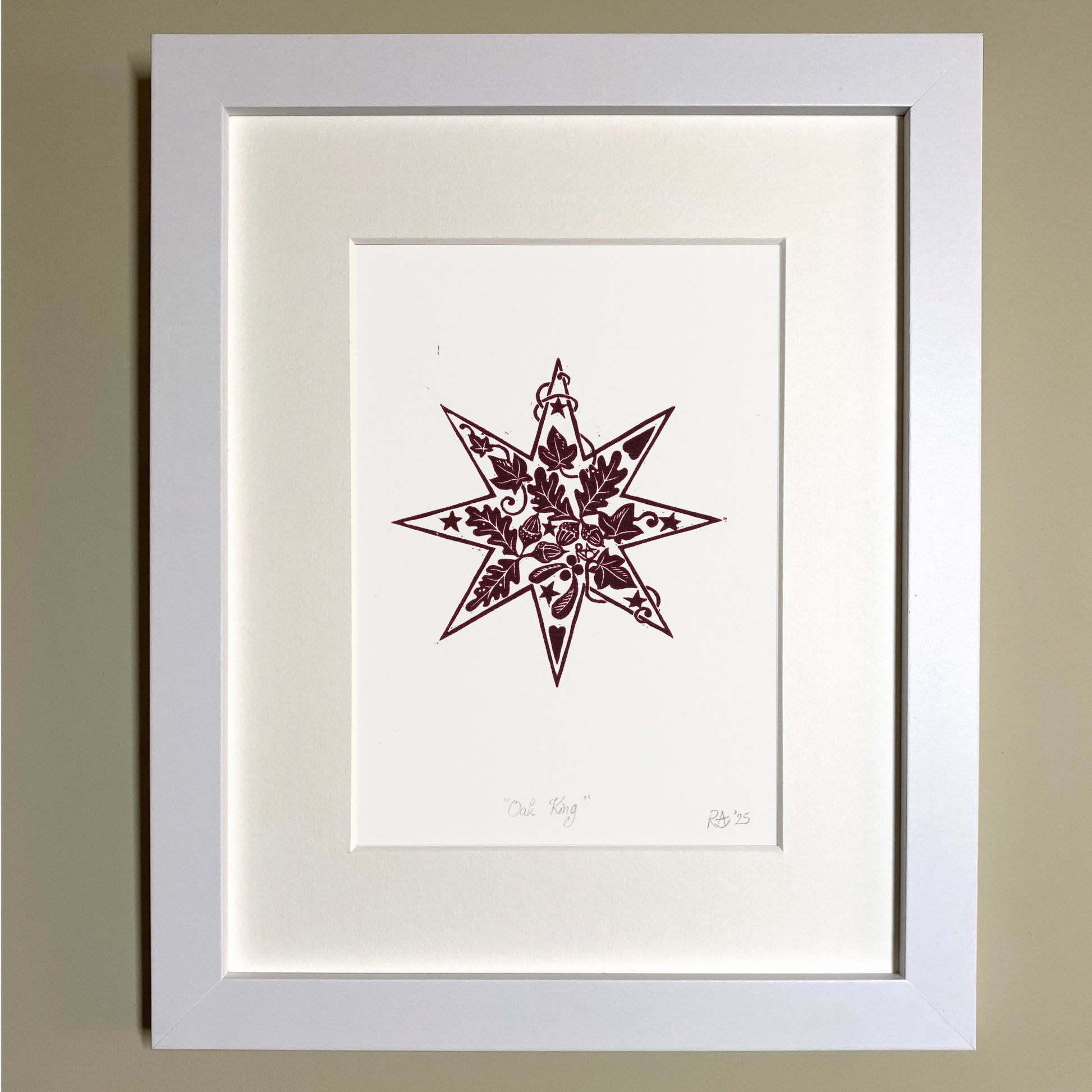 Framed artwork with a star design on a beige wall