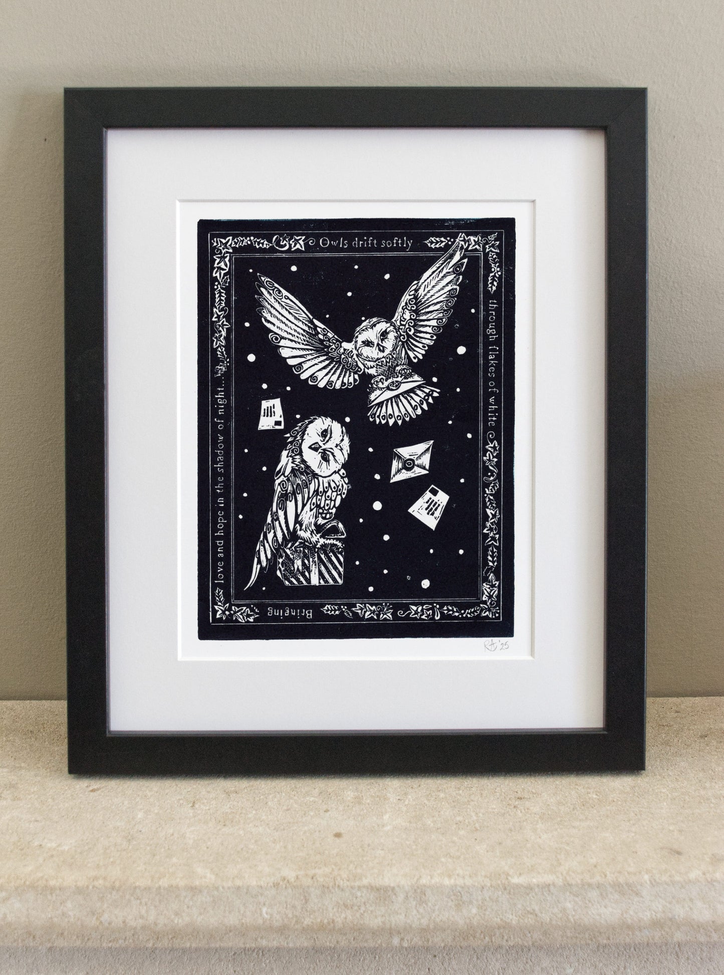 Framed artwork with a black and white illustration of an owl and skull on a starry night background.