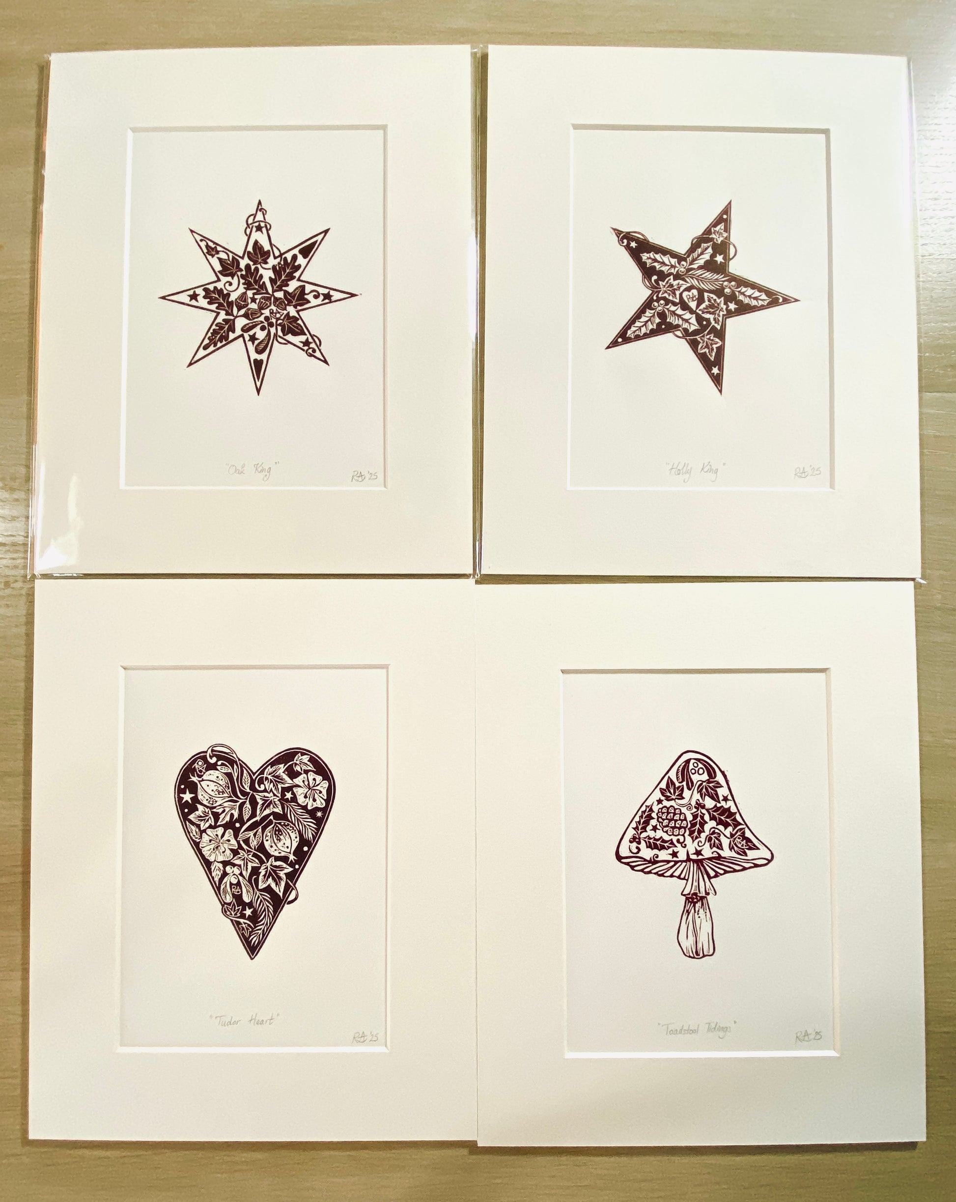 Four framed illustrations of a star, heart, mushroom, and other shapes on a wooden surface.
