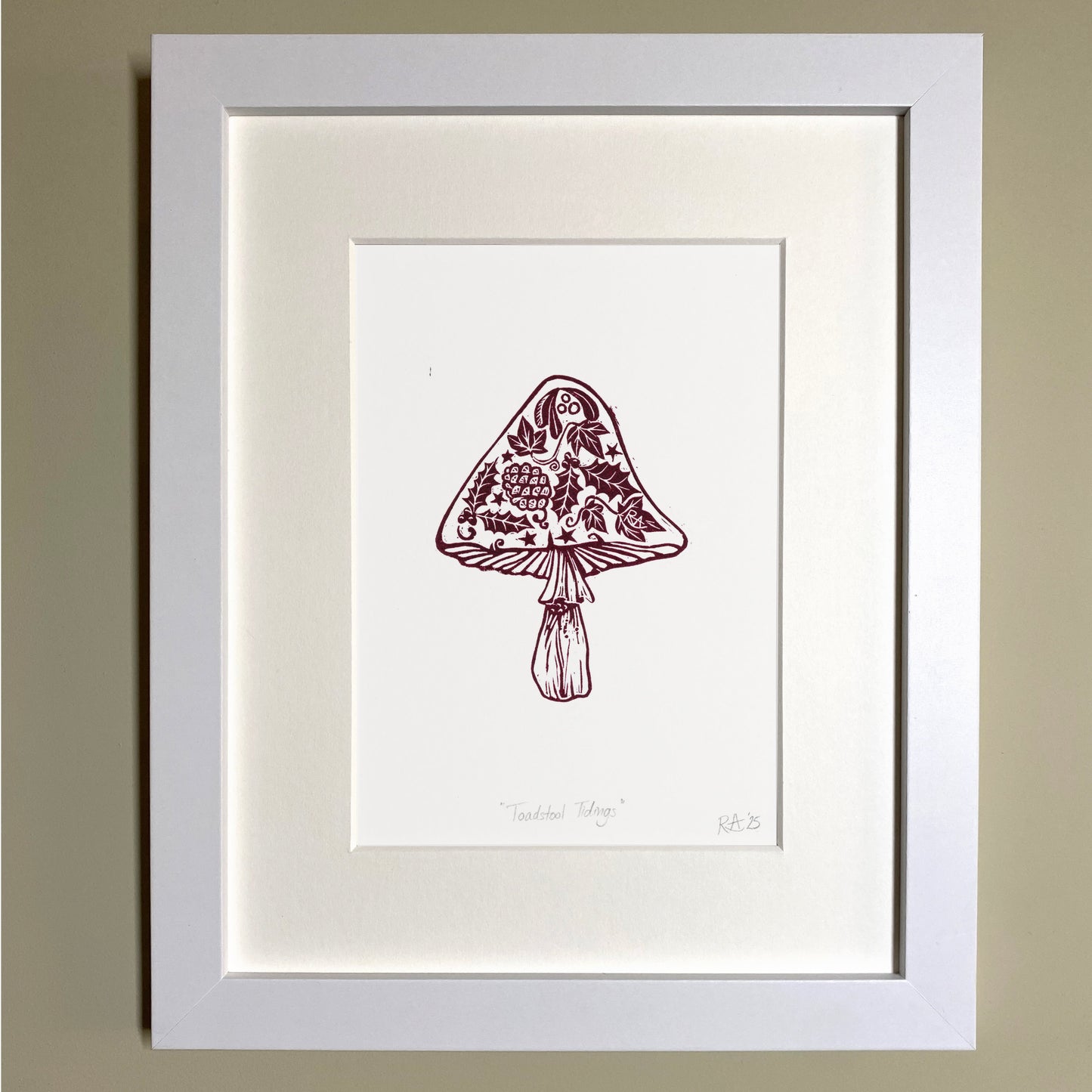 Framed Christmas artwork of a mushroom with floral design on a beige wall