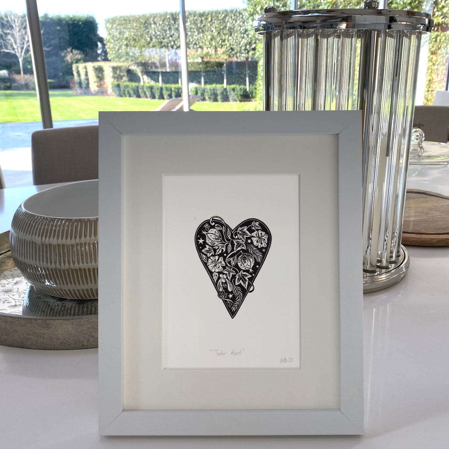 Framed artwork with a heart design on a table