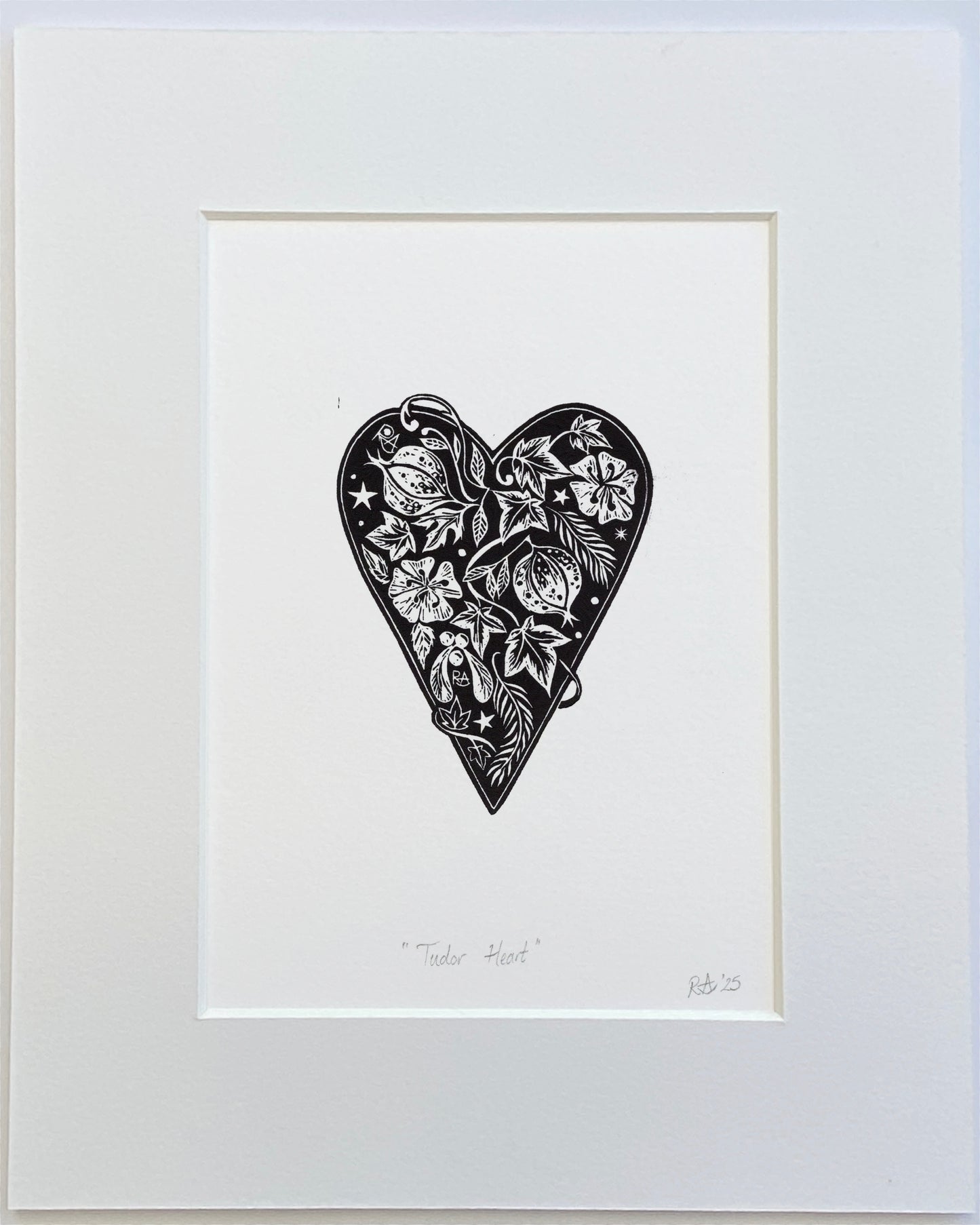 Framed black and white artwork of a heart with intricate patterns on a white background