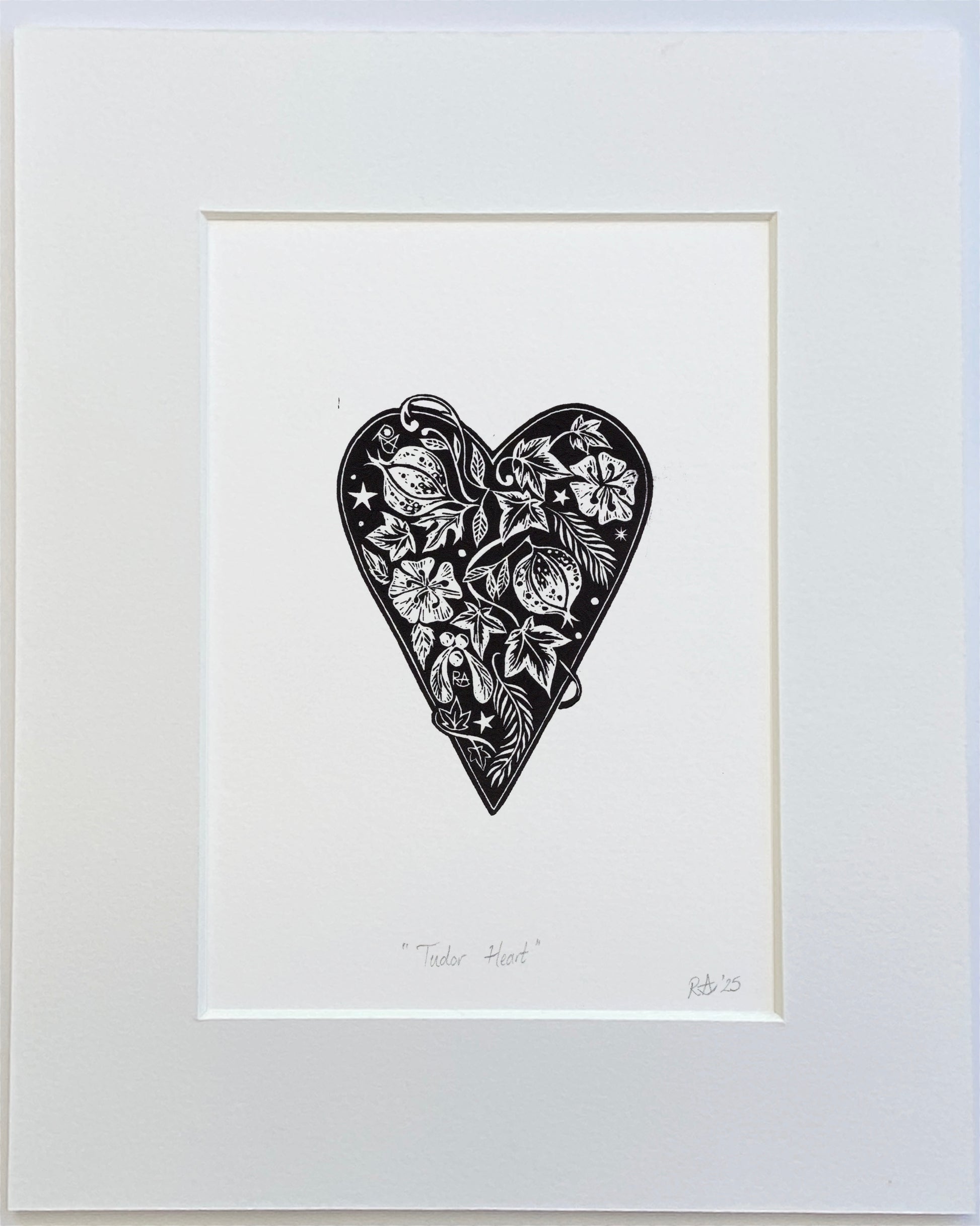 Framed black and white artwork of a heart with intricate patterns on a white background