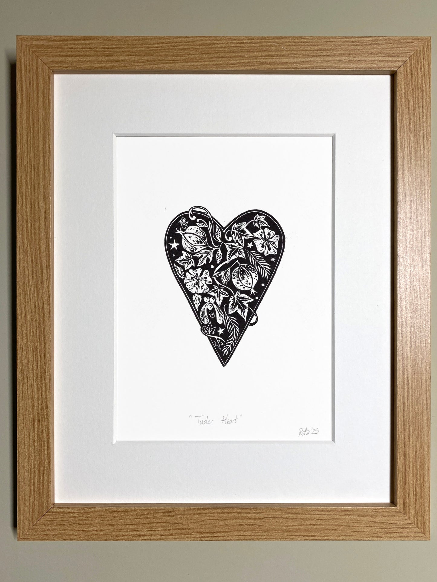 Framed artwork of a black tudor heart with floral patterns on a white background
