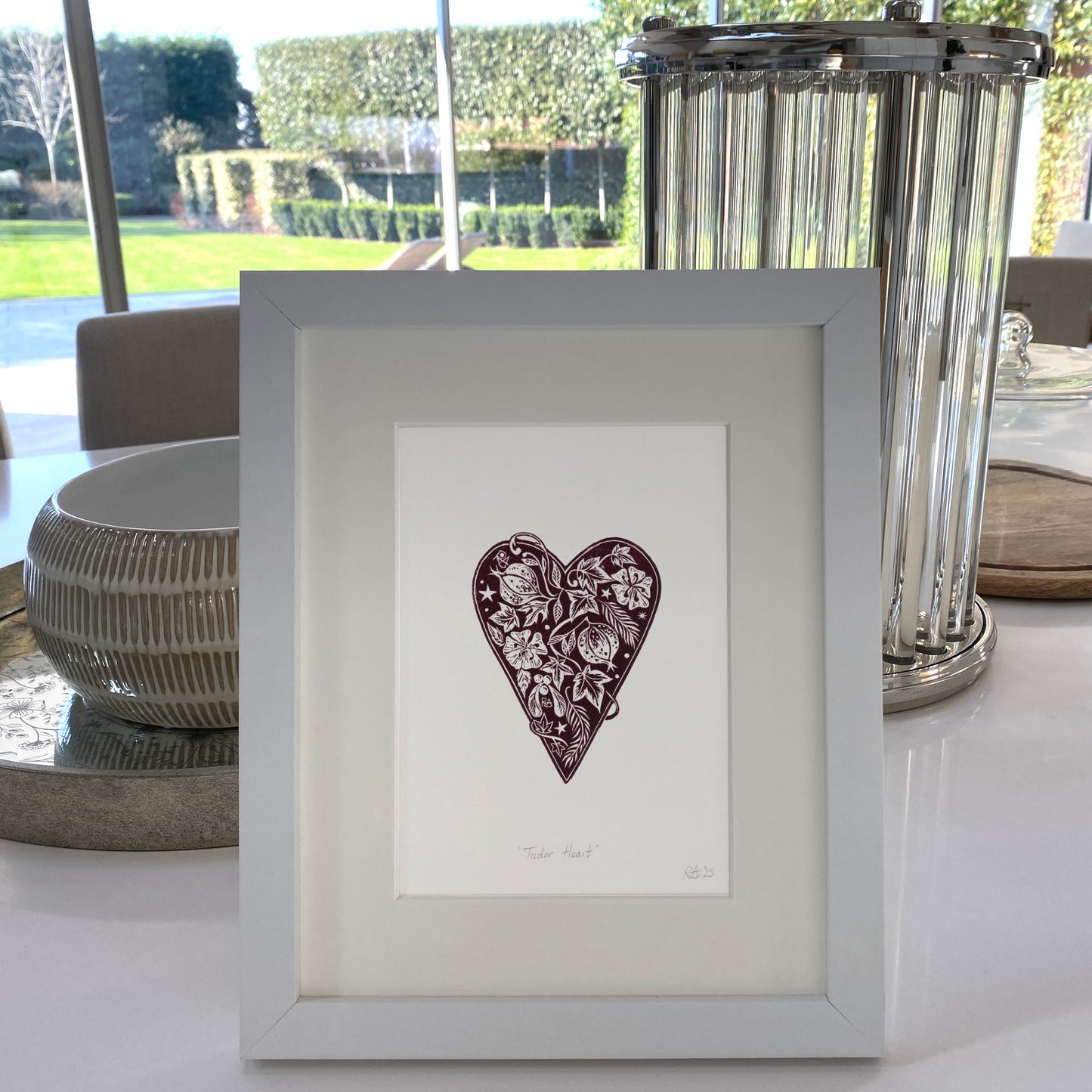 Framed artwork with a heart design on a table