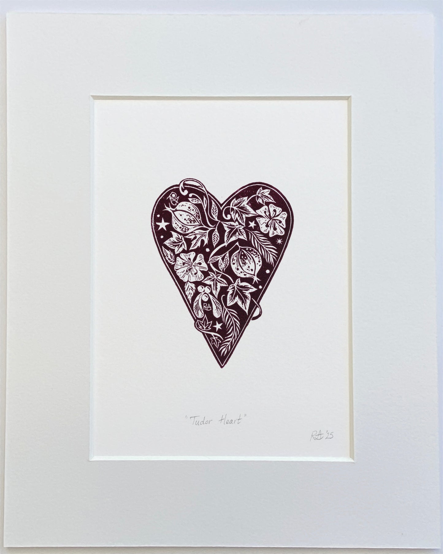 Framed artwork of a decorative heart with floral patterns on a white background