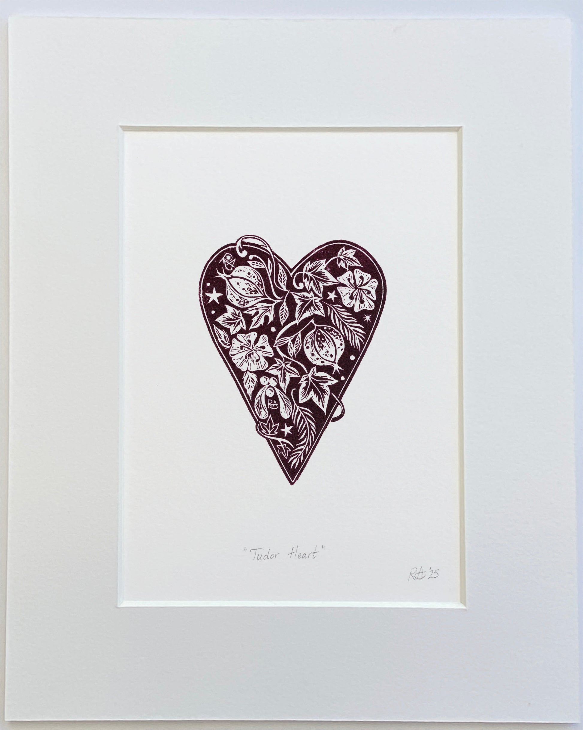Framed artwork of a decorative heart with floral patterns on a white background
