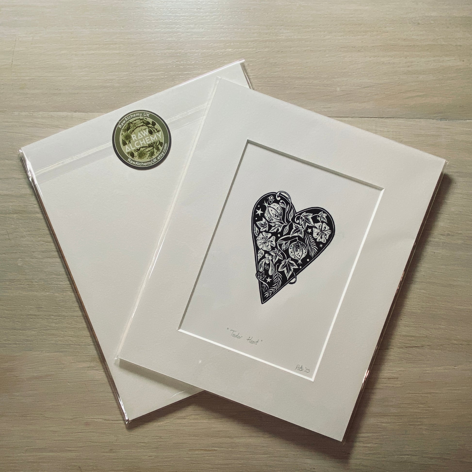 Matted artwork of a heart design on a wooden surface