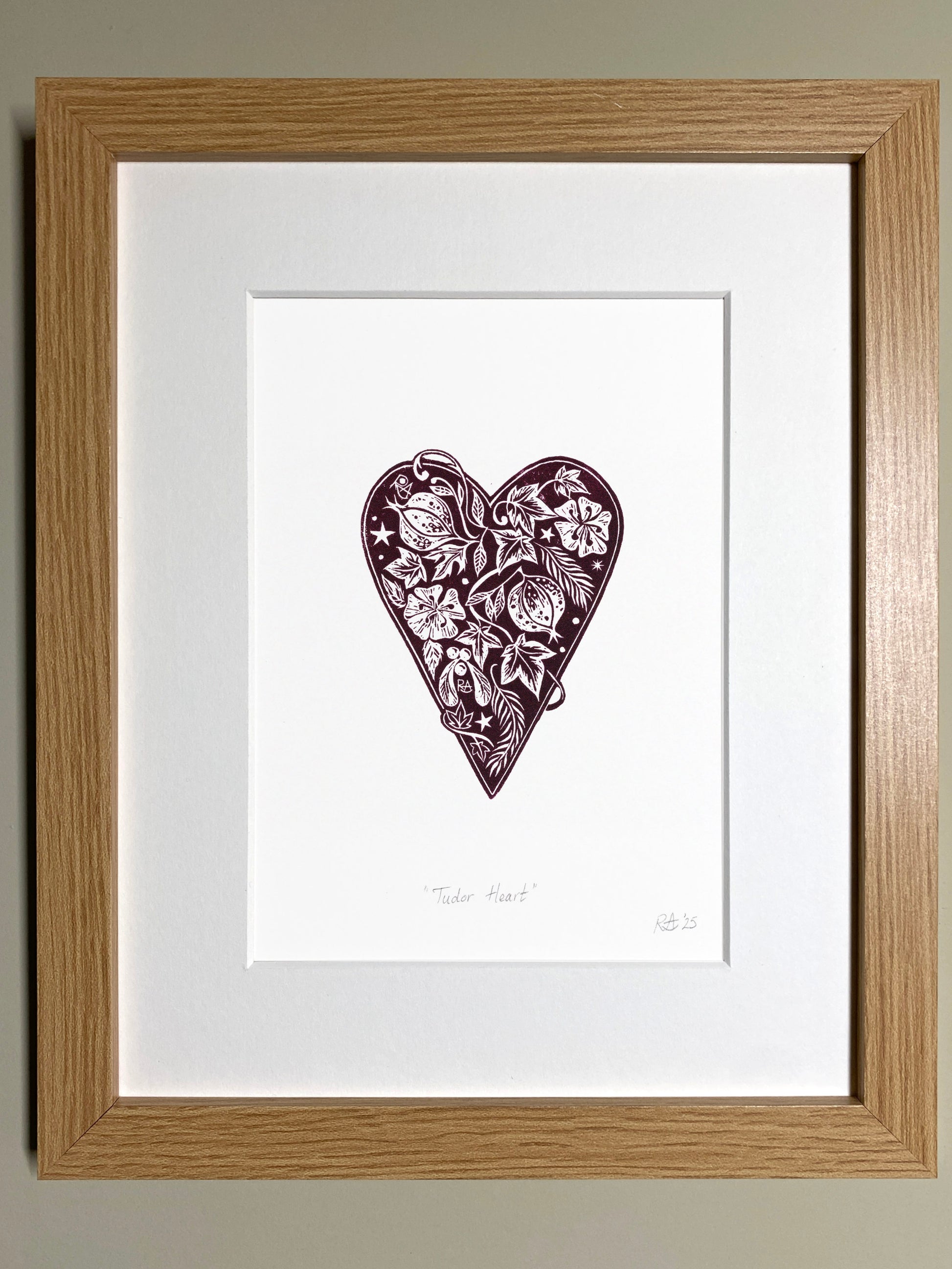 Framed artwork of a heart with floral patterns on a white background